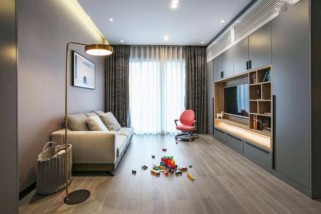 今天分享的是一套建筑面積102平米的現(xiàn)代輕奢風(fēng)三居室案例，屋主夫妻和女兒、母親一家四口人居住，整體來說是比較緊湊的剛需三房案例，設(shè)計(jì)師以輕松、時(shí)尚的灰色調(diào)作為主色，搭配格調(diào)滿滿的木質(zhì)家具，營(yíng)造出簡(jiǎn)約、輕奢的感覺。    平面布置圖    入戶玄關(guān)和餐廳連在了一起，利用了入戶門側(cè)方的墻面來做上一整墻的柜子，把鞋柜和餐邊柜結(jié)合在一起使用，更為省空間。    復(fù)古的木質(zhì)餐桌椅到灰色調(diào)的背景，金屬質(zhì)感的吊燈，整個(gè)餐廳看起來非常有格調(diào)感。在餐桌椅側(cè)方加上隔板的設(shè)計(jì)，增強(qiáng)儲(chǔ)物能力。    位于餐廳另一側(cè)的就是客廳空間了，客廳的茶幾被舍棄，中間留空方便作為孩子的娛樂區(qū)，米色布藝沙發(fā)和暖灰色背景墻讓人感覺更加溫馨。    客廳的電視背景墻則是被利用起來做了收納，整墻的柜子留空電視周邊的部分區(qū)域，加上藏光之后使用更方便，看起來也更大氣。    廚房?jī)?nèi)部的櫥柜延續(xù)了客餐廳的柜子顏色，深灰色的大理石墻磚搭配灰色的啞光地磚，整個(gè)廚房看起來很有現(xiàn)代感。    臥室選擇了以藍(lán)灰色為主，在臥室頂部吊頂內(nèi)加上藏光，用吊燈、臺(tái)燈等代替主燈，讓臥室看起來更為簡(jiǎn)潔。    在主臥室里還有一個(gè)迷你的衣帽間，U字形布局的柜子把角落空間充分用上。衣帽間外的床頭柜改成了梳妝臺(tái)，使用起來更加方便。    老人房選擇了榻榻米床組合衣柜和書桌的設(shè)計(jì)，榻榻米的安全性會(huì)更高一些，加上一張書桌也方便屋主母親看看書。    衛(wèi)生間內(nèi)部是三角形的布局方案，鉆石形的淋浴房做在了轉(zhuǎn)角處，兩側(cè)擺放洗手臺(tái)和馬桶。洗手臺(tái)上方的鏡柜做了藏光的設(shè)計(jì)，看起來更時(shí)尚。